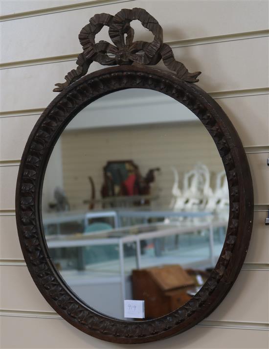 A carved oak circular framed wall mirror